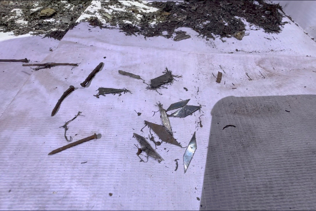 Đinh nhọn nằm rải rác trên mặt đường bị thanh nam châm hút dính.