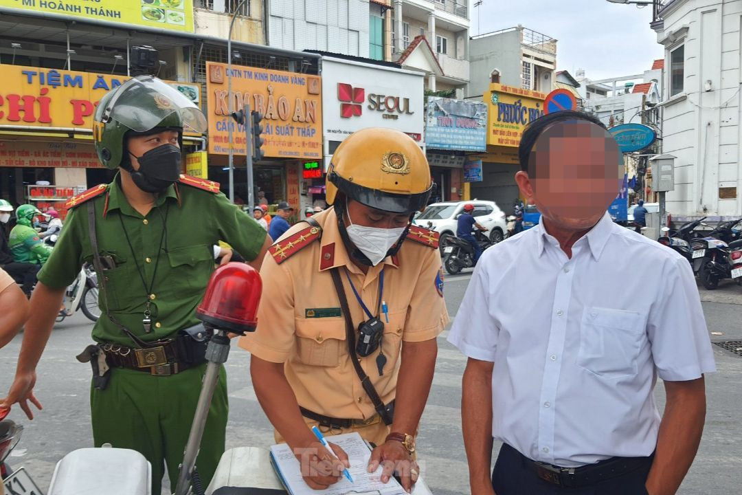 Lực lượng CSGT lập biên bản xử phạt hành chính đối với ông N.Q.T.. Ảnh: Hoàng Thuận