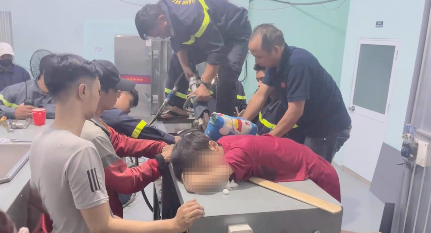 Lực lượng cứu hộ dùng thiết bị chuyên dụng cắt các bộ phận của máy trộn bột để đưa thiếu niên ra ngoài. Ảnh: PC07. Lực lượng cứu hộ dùng thiết bị chuyên dụng cắt các bộ phận của máy trộn bột để đưa thiếu niên ra ngoài. Ảnh: PC07.