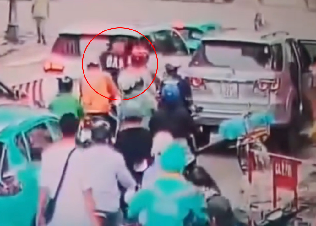 Nam tài xế (khoanh tròn đỏ) đánh tới tấp vào người đàn ông đi xe máy. Ảnh cắt từ clip. Nam tài xế (khoanh tròn đỏ) đánh tới tấp vào người đàn ông đi xe máy. Ảnh cắt từ clip.