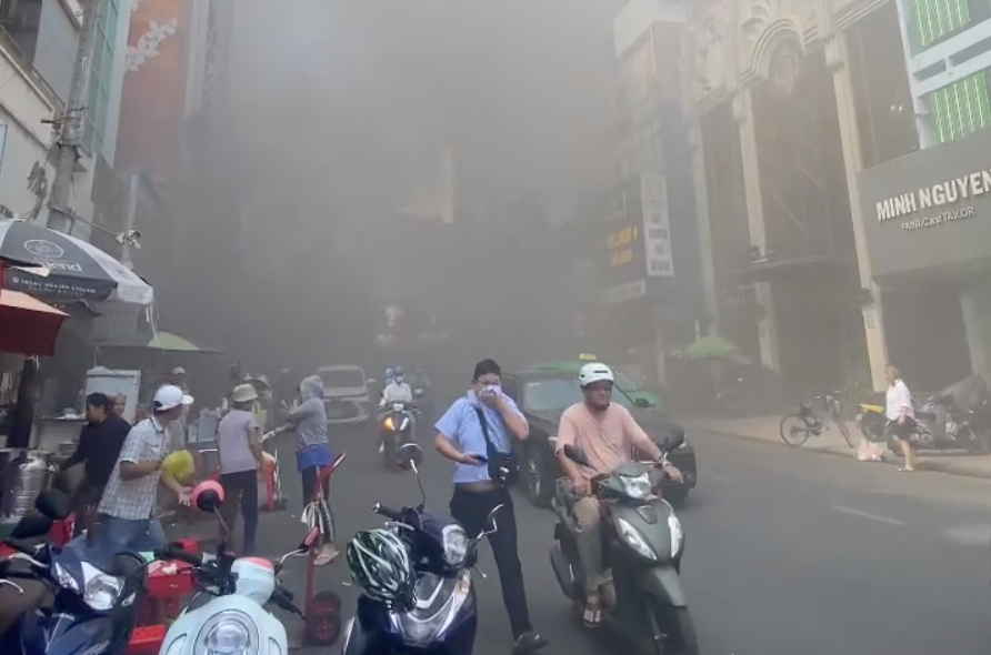 Người dân bịt mũi vì khói bốc lên từ đám cháy. Ảnh: A.X