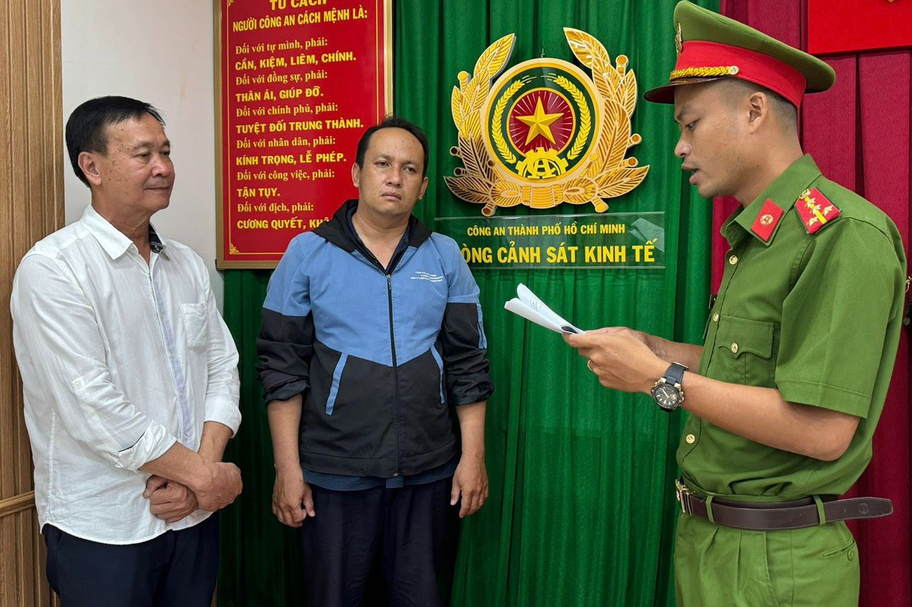 Cơ quan điều tra tống đạt các quyết định đối với ông Hồ Việt Tân (áo trắng) Bùi Huỳnh Bá Phước. Ảnh: Công an cung cấp. Cơ quan điều tra tống đạt các quyết định đối với ông Hồ Việt Tân (áo trắng) Bùi Huỳnh Bá Phước. Ảnh: Công an cung cấp.