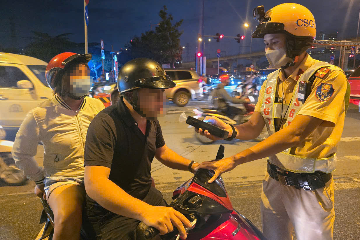 CSGT kiểm tra nồng độ cồn đối với người đi xe máy. Ảnh: C.A.