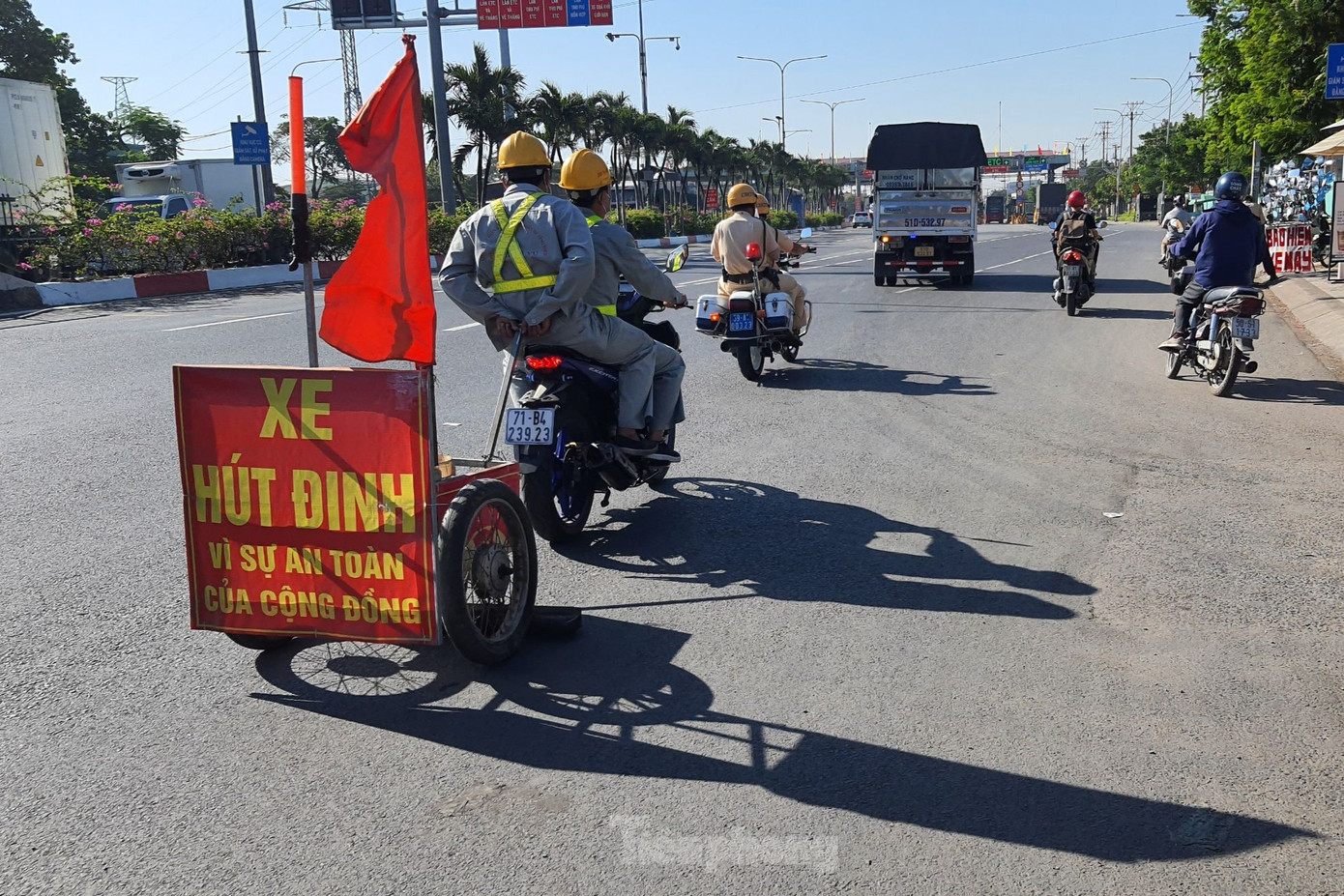 Công nhân Công ty cổ phần đầu tư và phát triển hạ tầng IDICO kéo xe tự chế hút đinh nhọn trên quốc lộ 1. Ảnh: Hoàng Thuận.