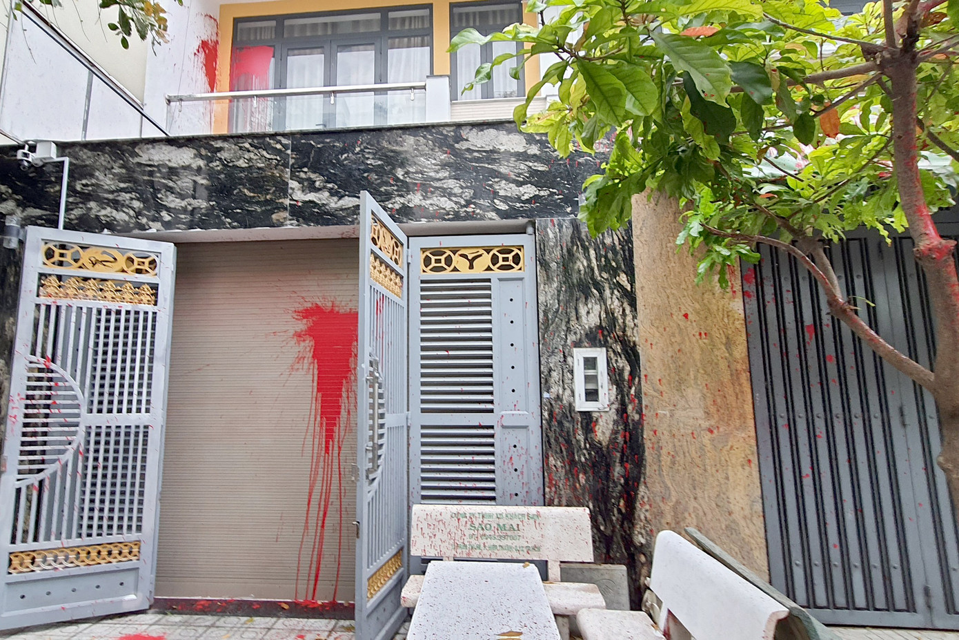 Sơn đỏ dính đầy cửa sắt, cửa cuốn và tường ở lầu 1. Ảnh: Hoàng Thuận. Sơn đỏ dính đầy cửa sắt, cửa cuốn và tường ở lầu 1. Ảnh: Hoàng Thuận.