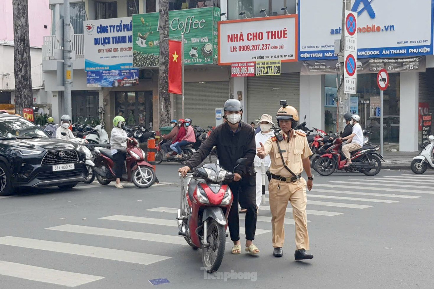 Nam thanh niên dừng xe máy không đúng vạch kẻ đường bị CSGT lập biên bản xử phạt. Ảnh: Hoàng Thuận.