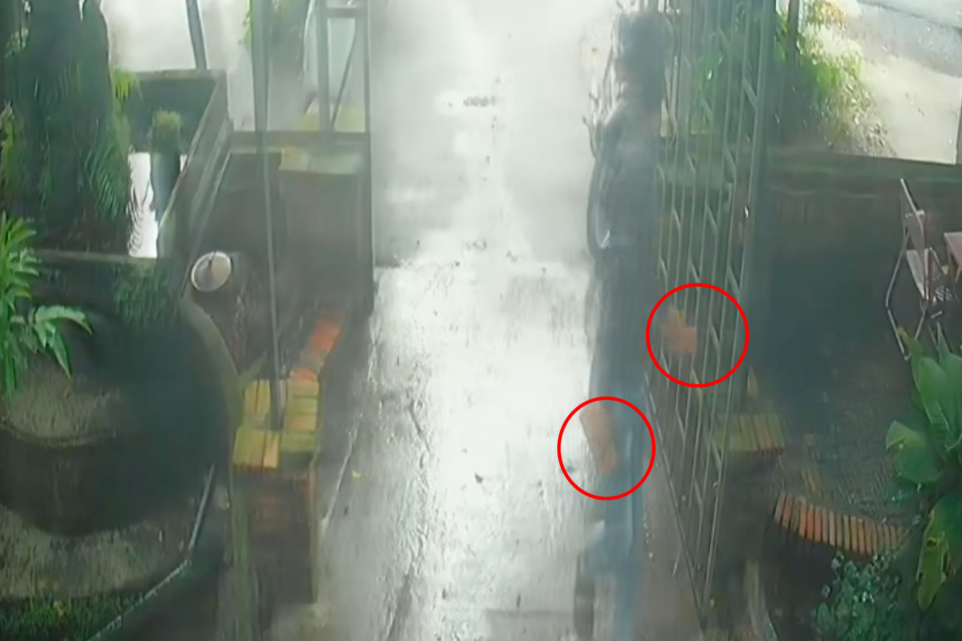 Nam thanh niên cầm 2 viên gạch ném vào quán cà phê của ông Đ. Ảnh cắt từ clip. Nam thanh niên cầm 2 viên gạch ném vào quán cà phê của ông Đ. Ảnh cắt từ clip.