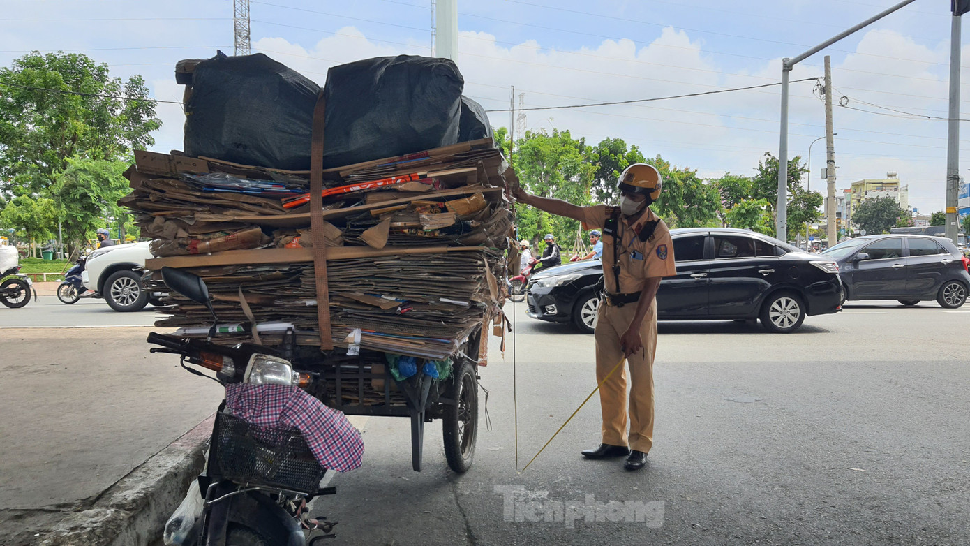 Xe máy gắn xe lôi tự chế chất thùng carton cao hơn 2m. Ảnh: Hoàng Thuận. Xe máy gắn xe lôi tự chế chất thùng carton cao hơn 2m. Ảnh: Hoàng Thuận.