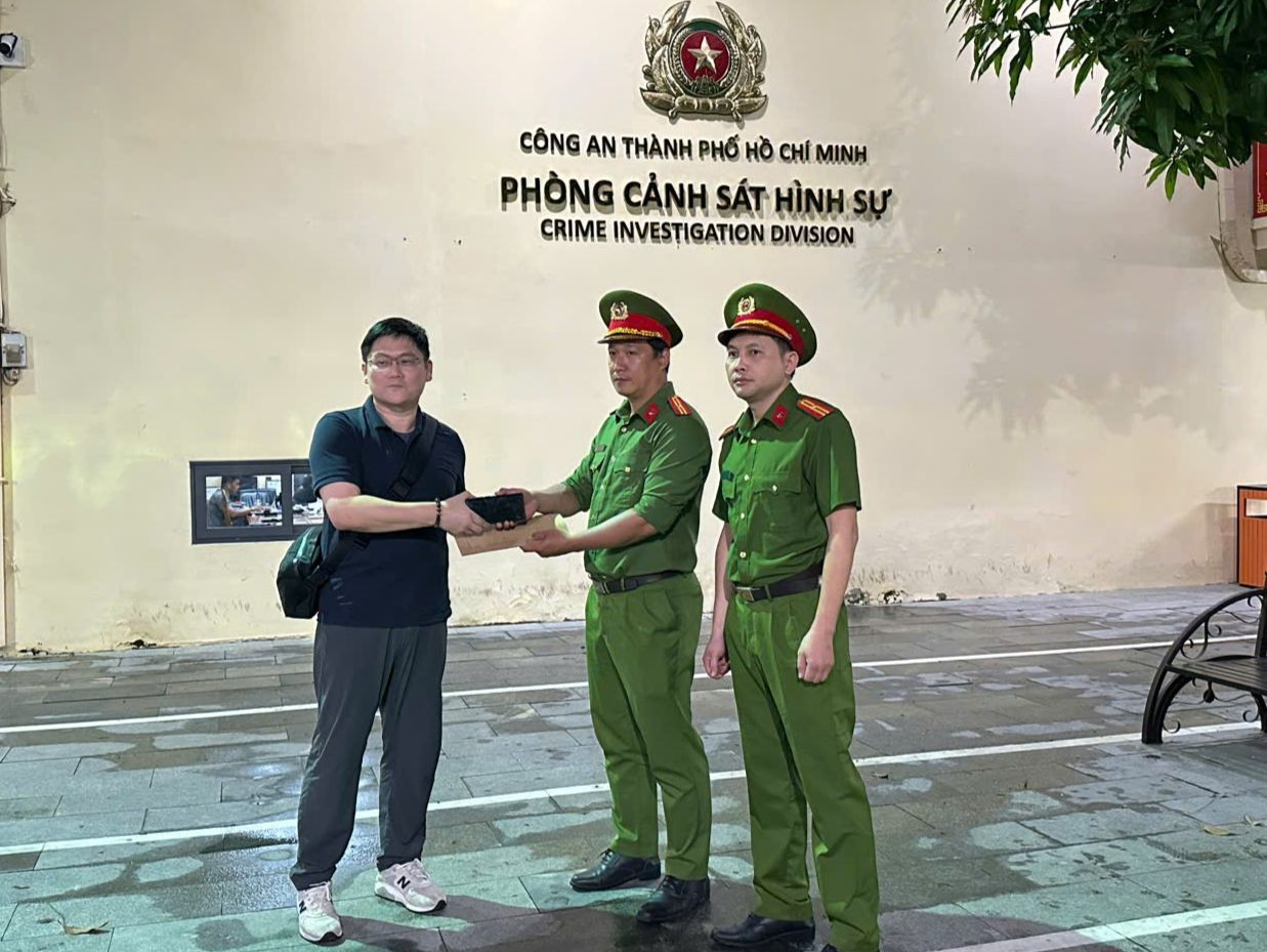 Đại diện Tổ công tác phá án trao trả lại điện thoại cho ông Teo Hwee Beng vào tối 27/8. Ảnh: Công an cung cấp.