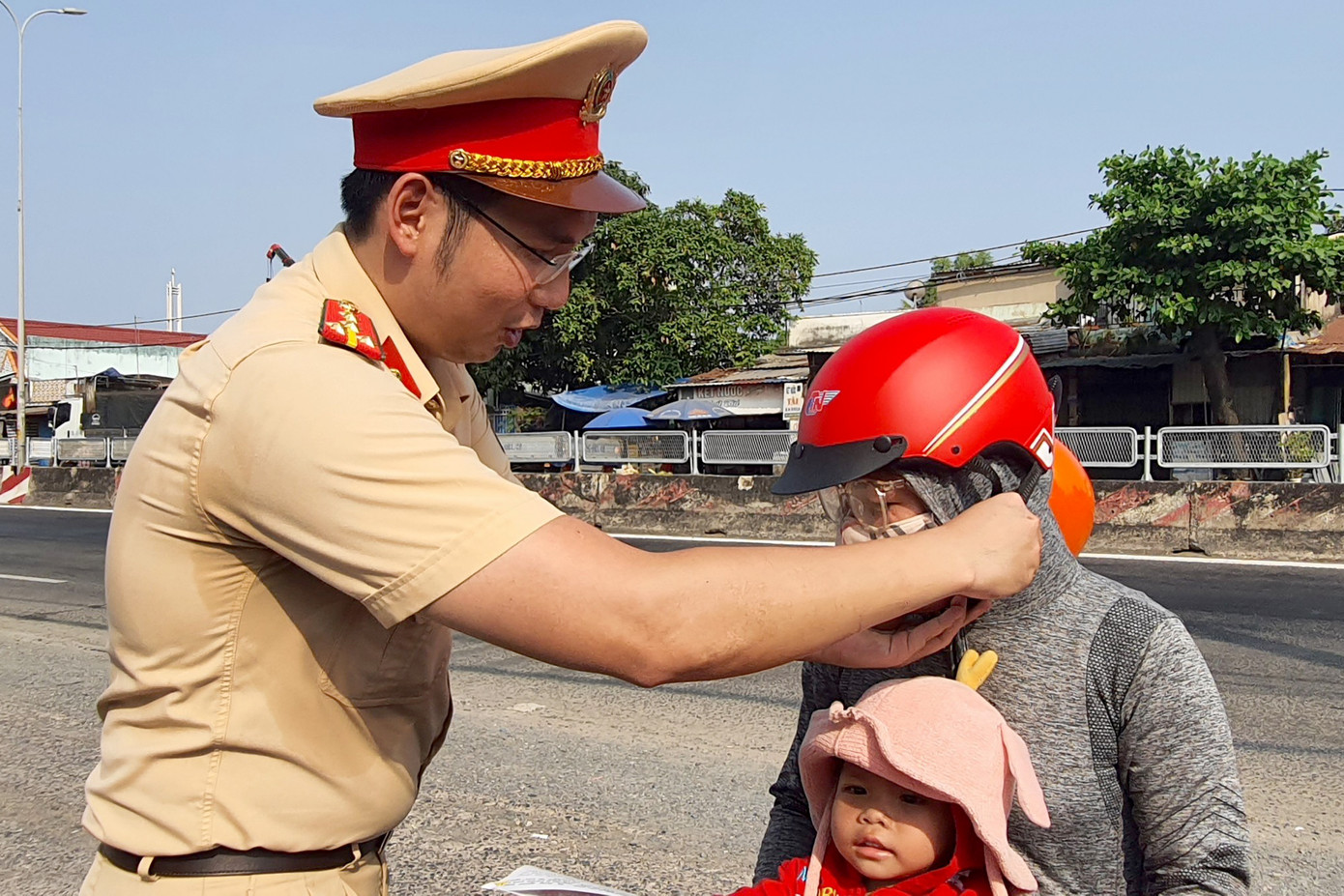 Chị Phượng được chiến sĩ CSGT tặng mũ bảo hiểm mới (Ảnh: Hoàng Thuận).
