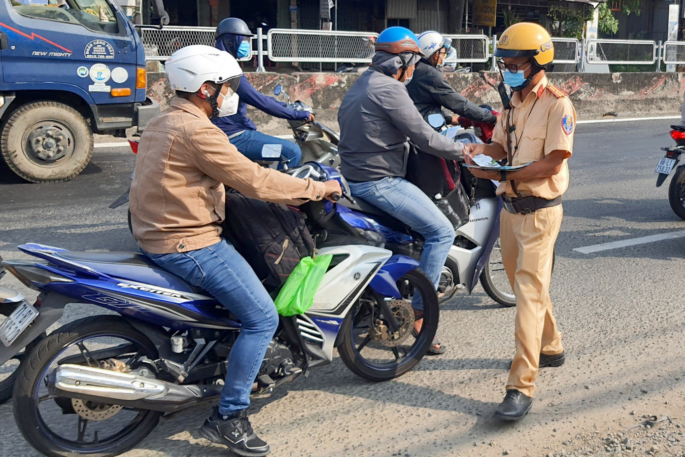 CSGT phát tờ rơi tuyên truyền về luật giao thông cho người đi đường (Ảnh: Hoàng Thuận).