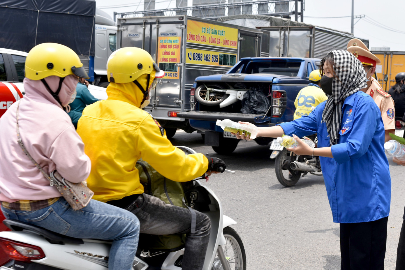 Người dân lưu thông trên quốc lộ 1 về quê nghỉ lễ được phát nước suối, khăn lạnh (Ảnh: Phạm Nguyễn).