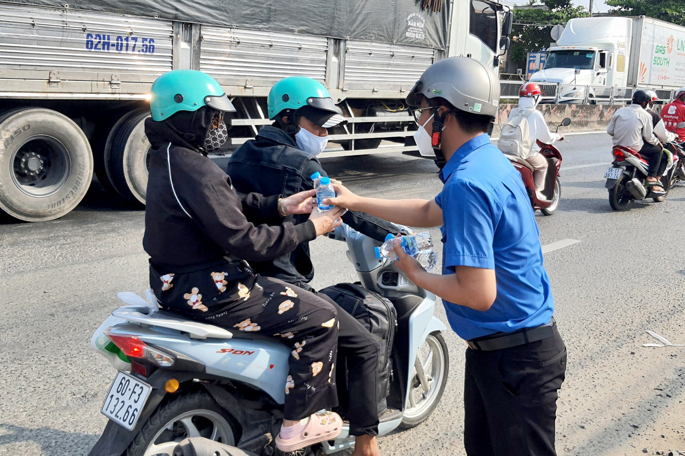 Các đoàn viên cũng tham gia phát nước suối người người dân (Ảnh: Hoàng Thuận).