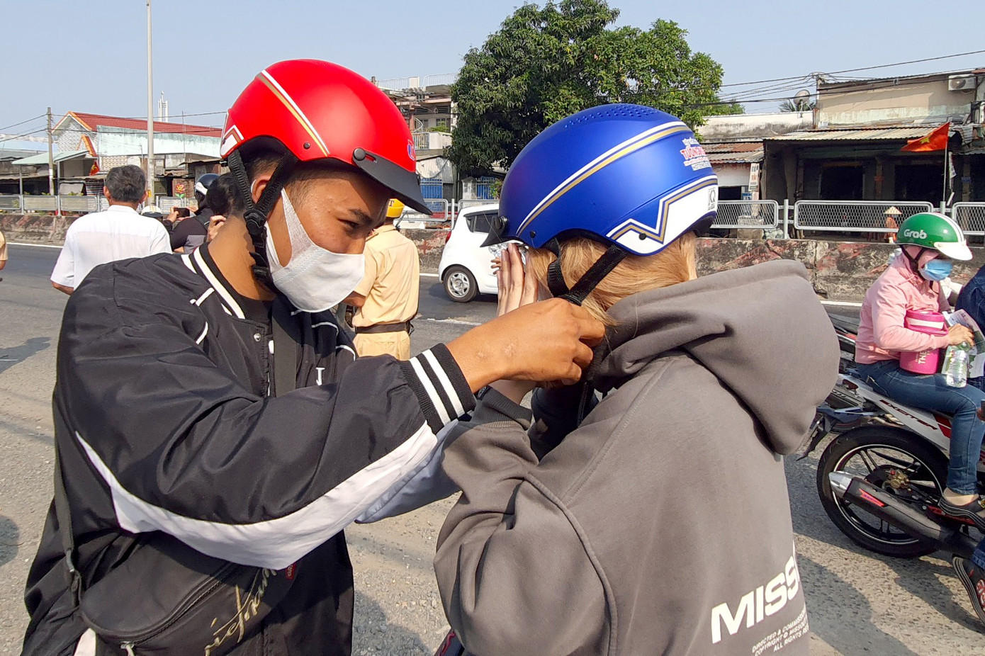 Đức và bạn gái được CSGT tặng mũ bảo hiểm mới để tham gia giao thông an toàn (Ảnh: Hoàng Thuận).