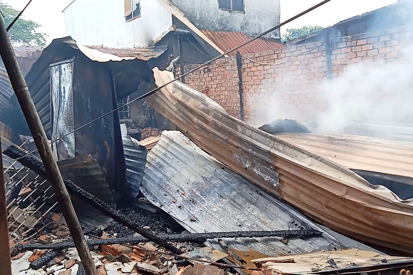 Mái tôn phòng trọ đổ sập sau vụ cháy (Ảnh: Hoàng Thuận).