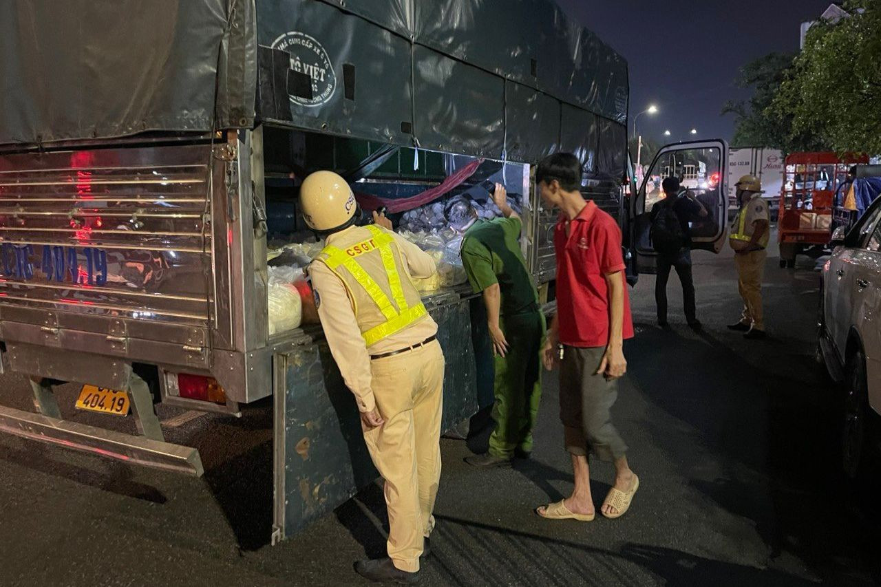 Lực lượng CSGT và Công an chức năng kiểm tra xe tải ra, vào ở chợ đầu mối nông sản Thủ Đức. Ảnh: A.X.