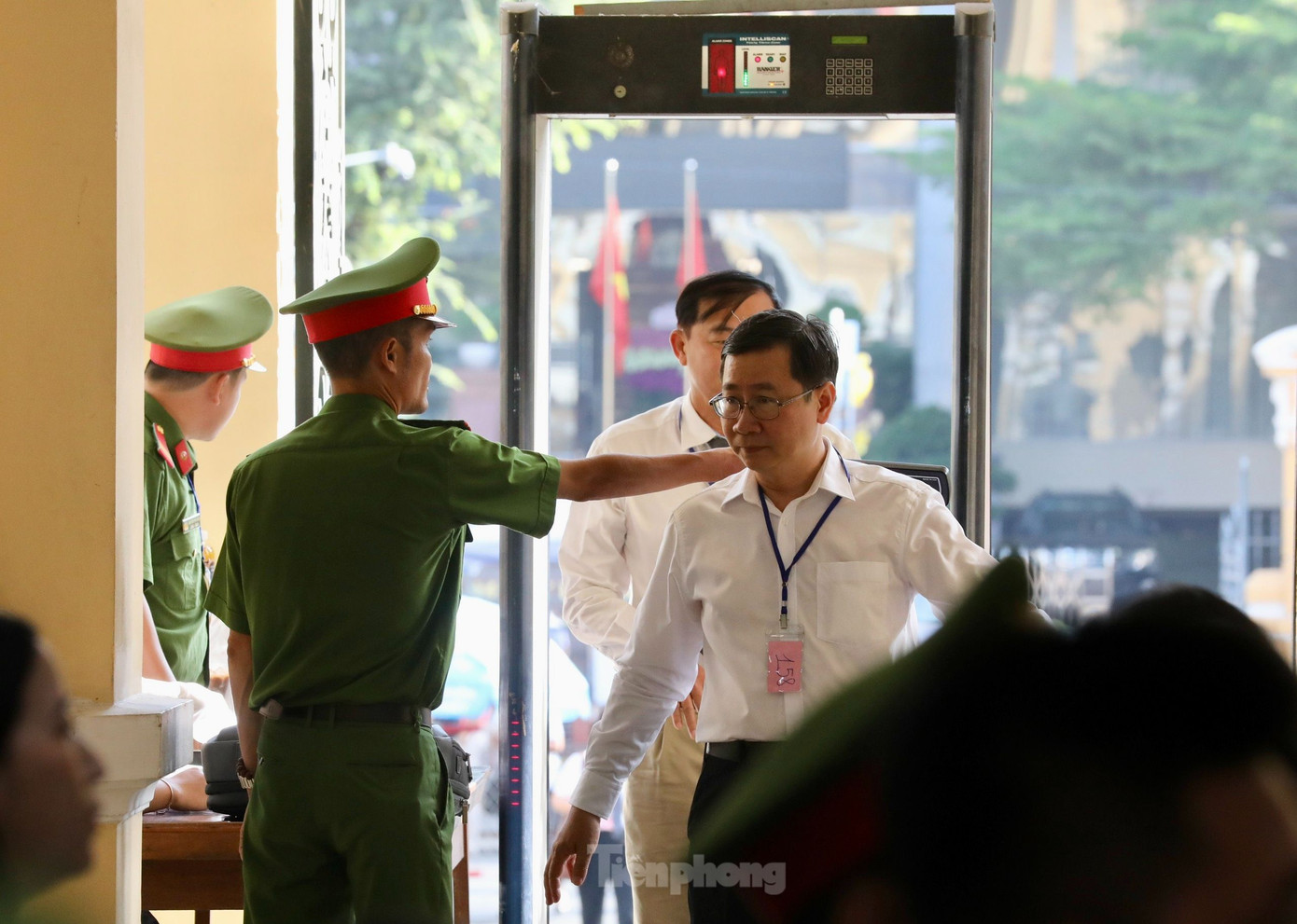 Lực lượng làm nhiệm vụ kiểm tra an ninh đối với người tham dự phiên tòa. Ảnh: Duy Anh.