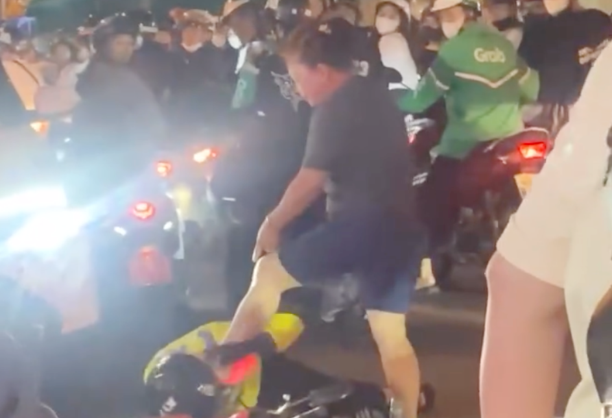 Người phụ nữ dùng chân đạp vào vùng đầu của tài xế xe ôm công nghệ. Ảnh cắt từ clip. Người phụ nữ dùng chân đạp vào vùng đầu của tài xế xe ôm công nghệ. Ảnh cắt từ clip.