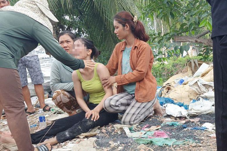 Người dân xung quanh động viên chủ xưởng nón bảo hiểm (người mặc quần đen). Ảnh: Hoàng Thuận. Người dân xung quanh động viên chủ xưởng nón bảo hiểm (người mặc quần đen). Ảnh: Hoàng Thuận.