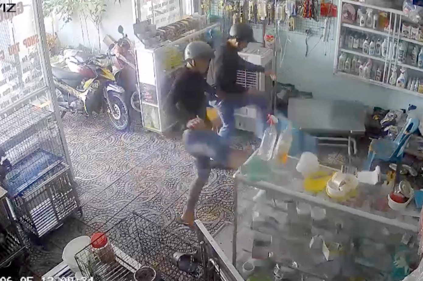 Hai thanh niên đập phá bàn ghế, tủ kính của phòng khám thú y (Ảnh cắt từ clip).