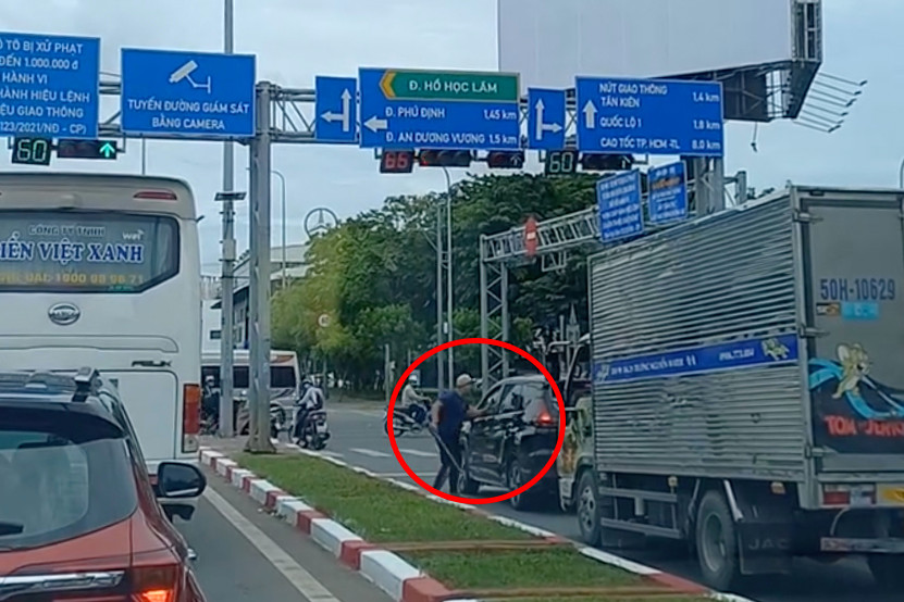 Ông N. cầm tuýp sắt "nói chuyện" với tài xế ô tô vì không được nhường đường. Ảnh cắt từ clip. Ông N. cầm tuýp sắt "nói chuyện" với tài xế ô tô vì không được nhường đường. Ảnh cắt từ clip.