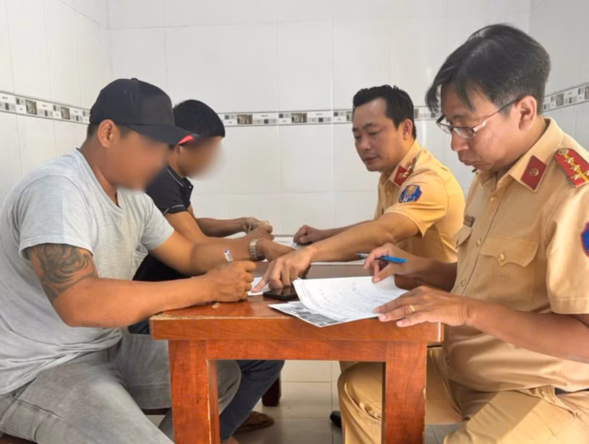 Lực lượng CSGT lập biên bản xử phạt đối với tài xế N. (áo xám). Ảnh: PC08.