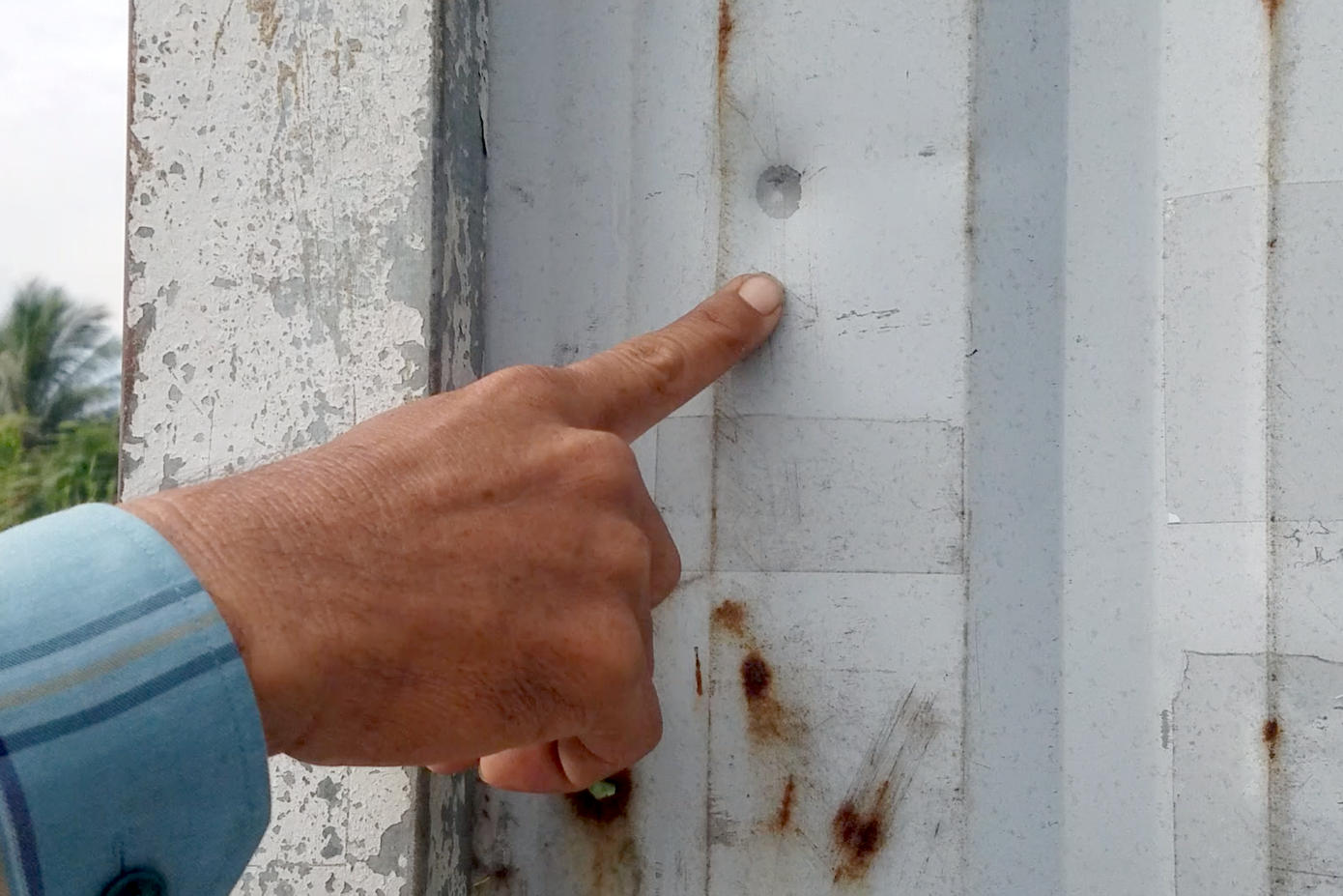 Dấu vết nghi của đạn cao su trên cánh cổng bằng tôn.