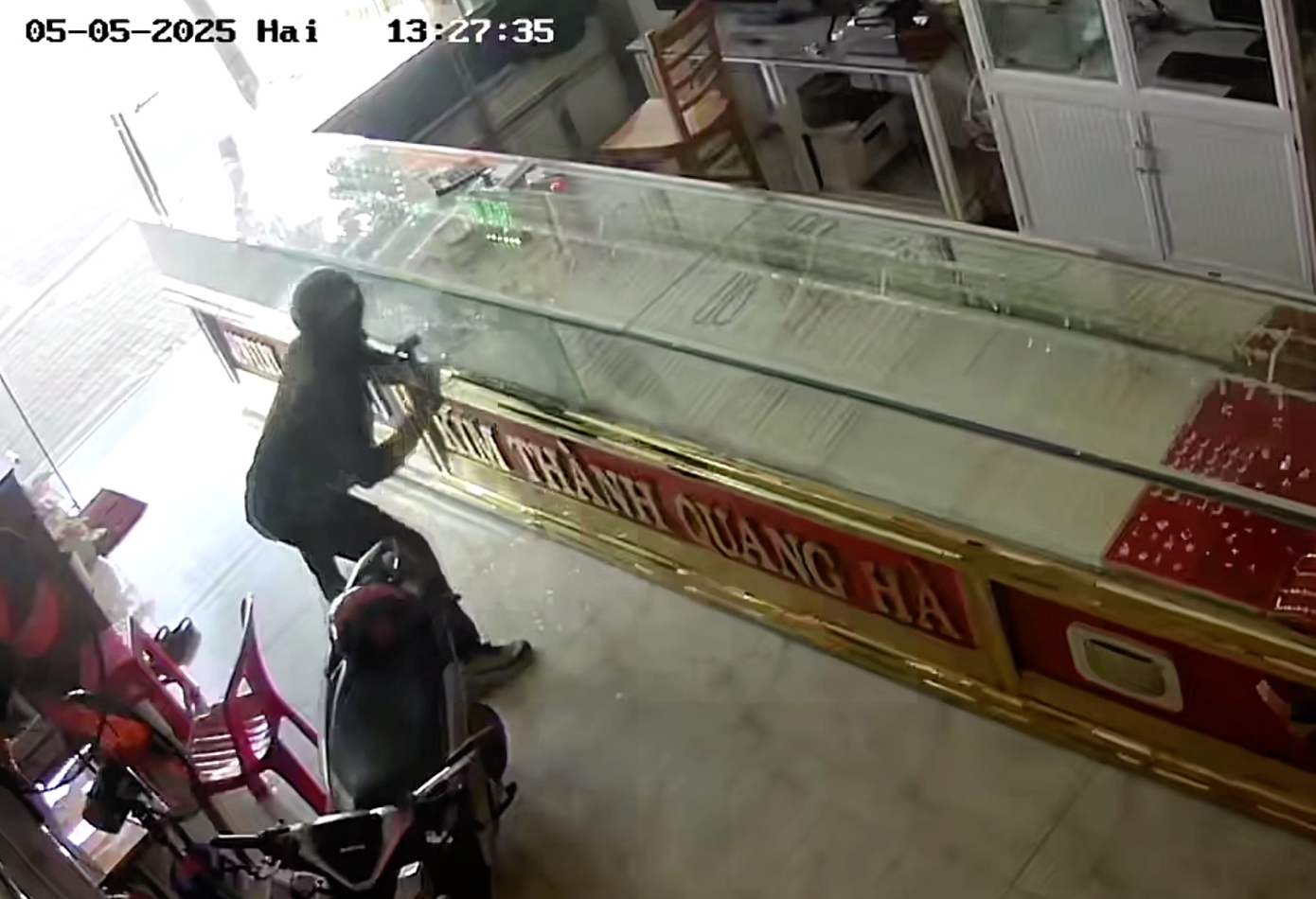 Hai anh em Đạt và Đông phân công người cảnh giới, người dùng búa đập kính để lấy vàng. Ảnh cắt từ clip.