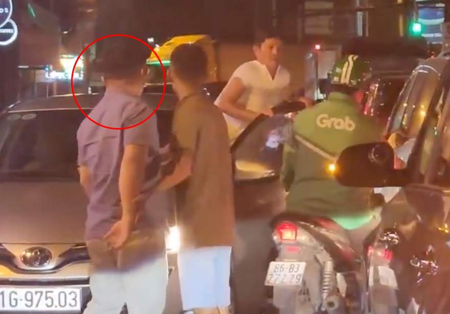 Thịnh (khoanh tròn đỏ) và ông Phương (người mặc áo trắng) chửi mắng anh M. (người ngồi trên xe máy. Ảnh cắt từ clip. Thịnh (khoanh tròn đỏ) và ông Phương (người mặc áo trắng) chửi mắng anh M. (người ngồi trên xe máy. Ảnh cắt từ clip.