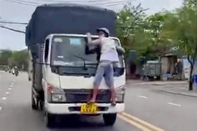 Tài xế Sa vẫn cho xe chạy trên đường dù anh T. đang bám trước kính chắn gió. Ảnh cắt từ clip.