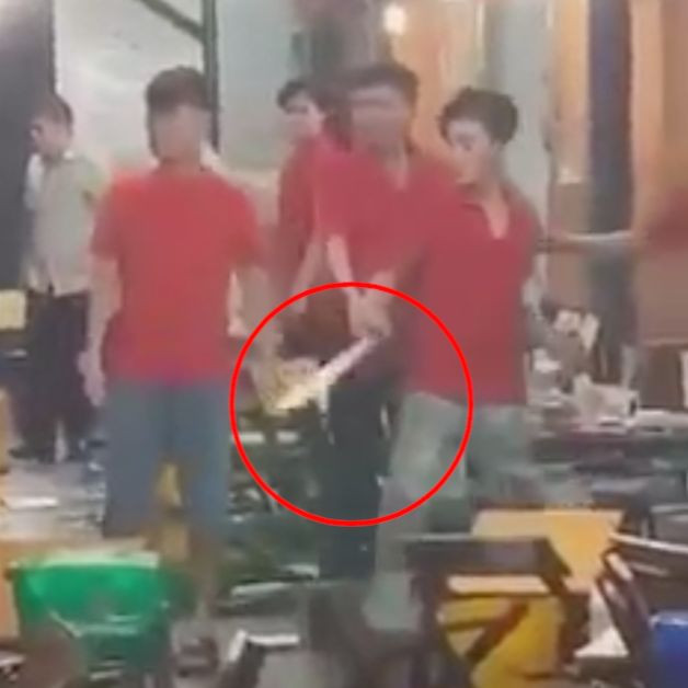 Nam nhân viên cầm mã tấu đe dọa khi thấy đồng nghiệp bị ném ly bia (Ảnh cắt từ clip).
