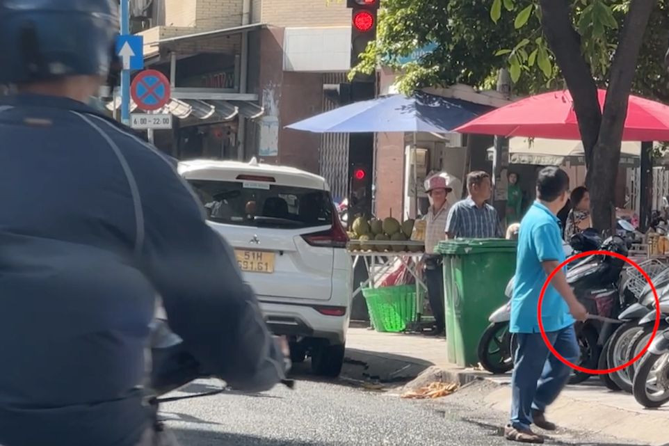 Nam tài xế công nghệ cầm con dao (khoanh tròn đỏ) trên tay. Ảnh cắt từ clip.