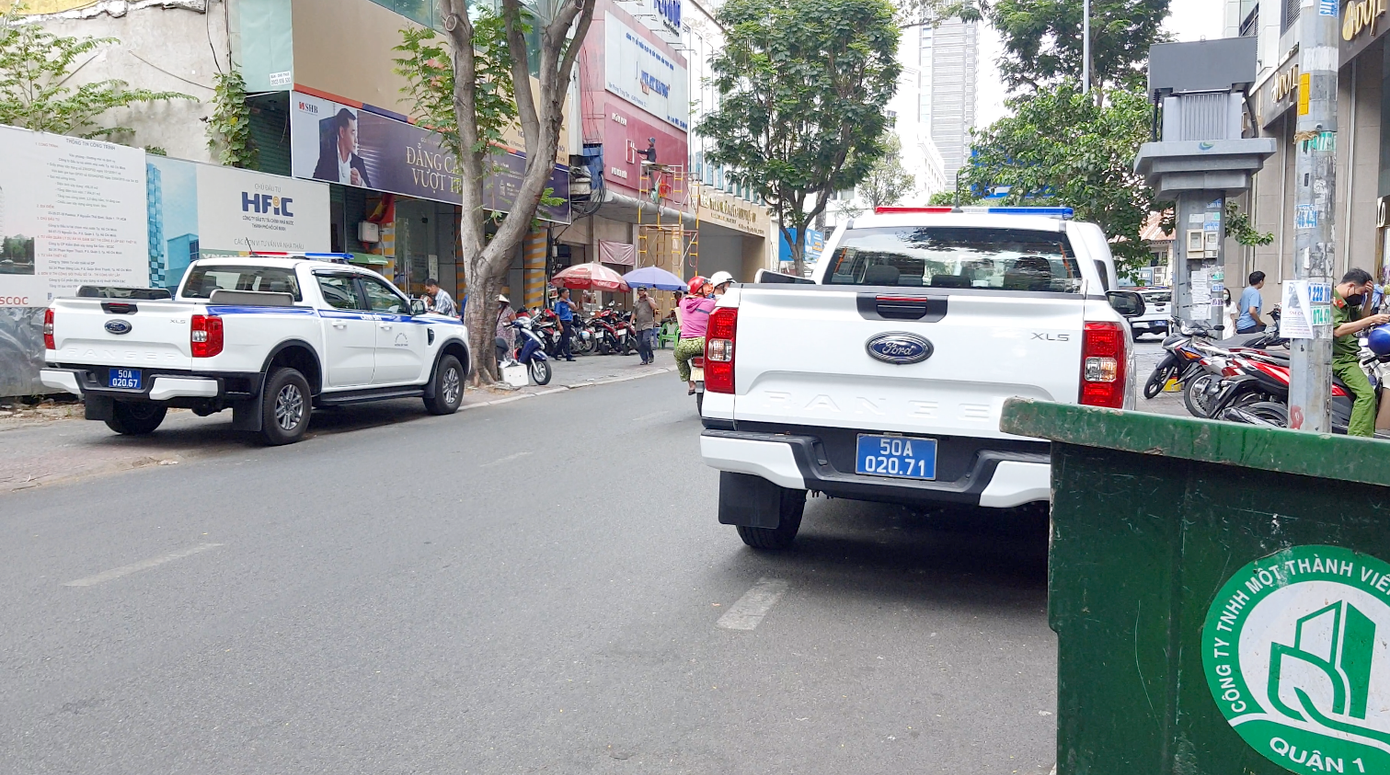 Xe công an đậu hai bên đường ở trước tòa nhà. Ảnh: Minh Anh.