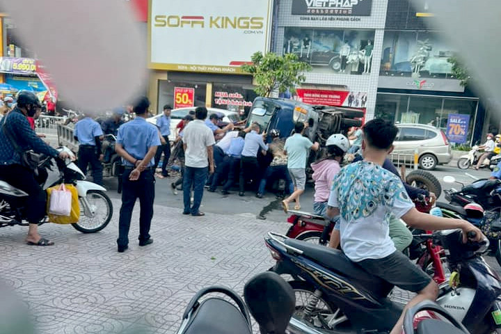 Người dân nâng xe ben để đưa nạn nhân ra ngoài. Ảnh: A.X. Người dân nâng xe ben để đưa nạn nhân ra ngoài. Ảnh: A.X.