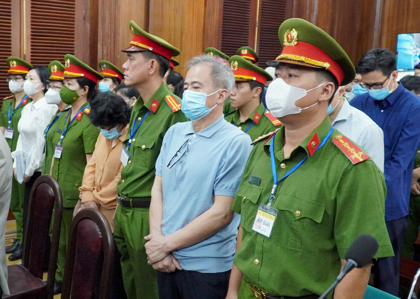 Bị cáo Nguyễn Văn Hưng (đeo kính ở ngực) và bị cáo Đỗ Thị Nhàn (áo vàng) tại phiên tòa.