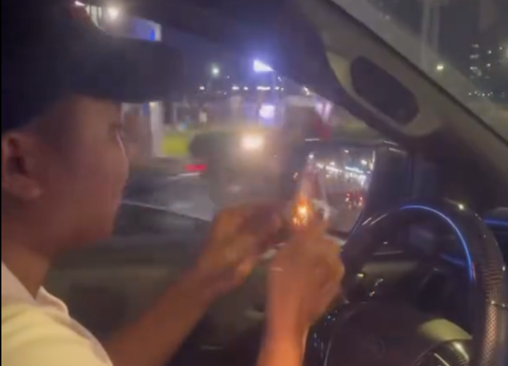 Nam thanh niên vừa lái ô tô vừa đốt pháo ném xuống đường. Ảnh cắt từ clip. Nam thanh niên vừa lái ô tô vừa đốt pháo ném xuống đường. Ảnh cắt từ clip.