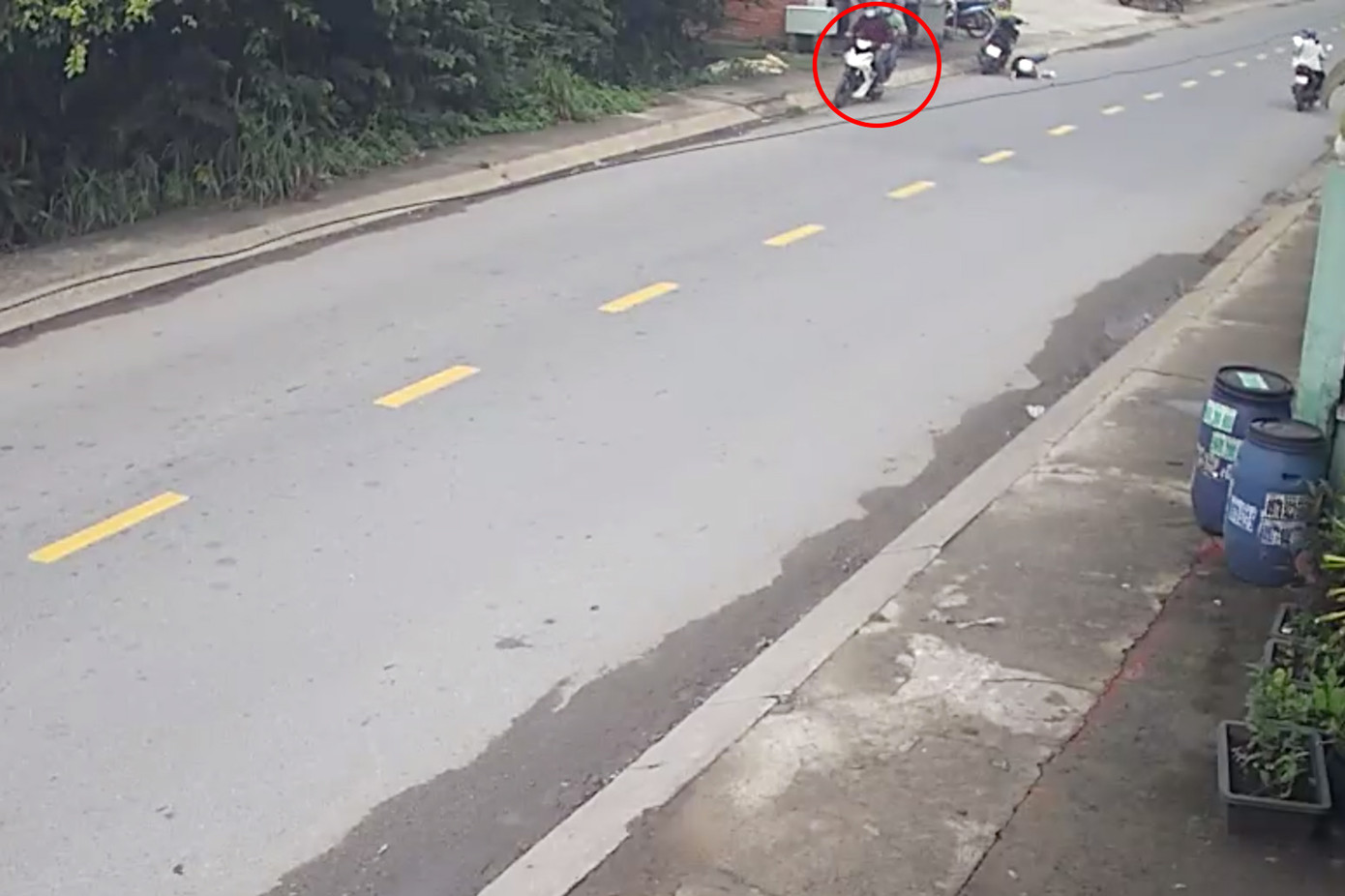 Chị P đang dừng xe mua đồ ăn sáng thì bị giật sợi dây chuyền trị giá hơn 12 triệu đồng (Ảnh cắt từ clip).