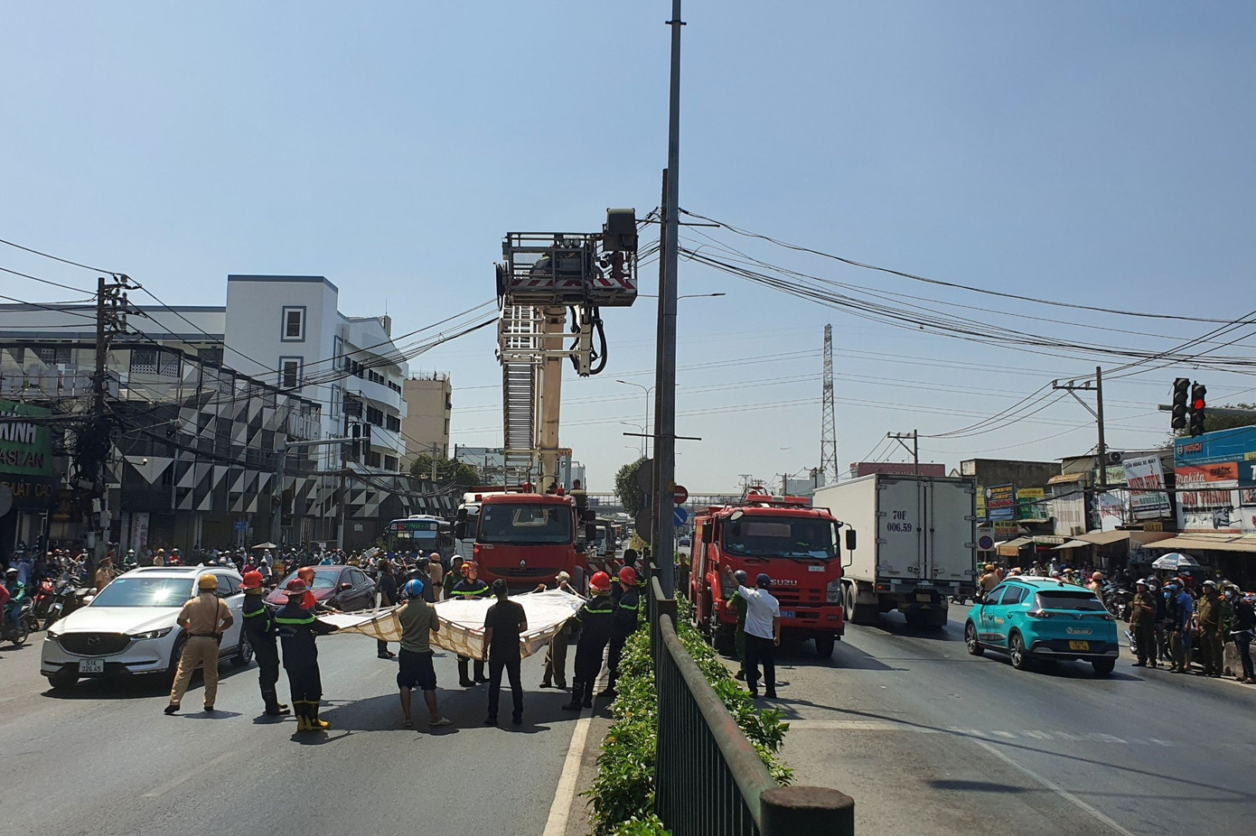 Lực lượng chức năng căng bạt bên dưới để đề phòng nam thanh niên nhảy xuống bất ngờ.