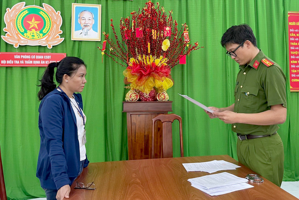 Cơ quan điều tra tống đạt các quyết định đối với bà Quyên. Ảnh: Công an cung cấp.