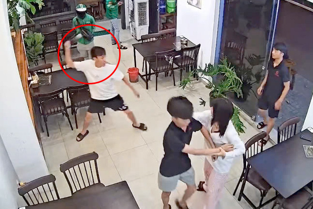 Camera ghi cảnh Phương dùng chai rượu ném vỡ cửa kính. Ảnh cắt từ clip.