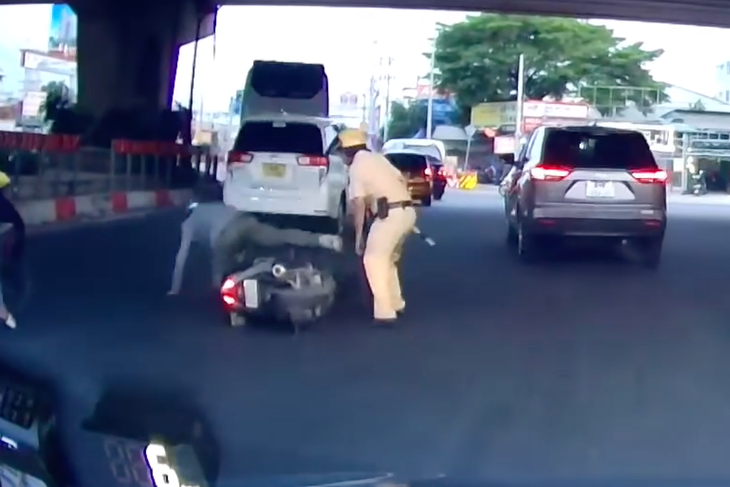 Ông T. ngã xuống đường khi tông vào chân CSGT. Ảnh cắt từ clip.