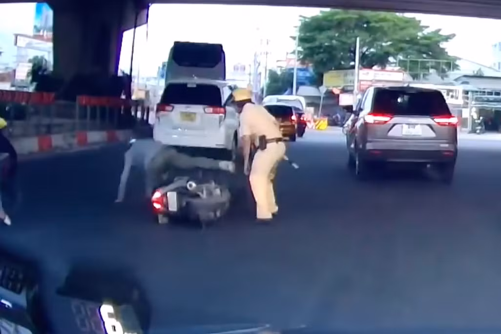 Ông T. ngã xuống đường khi tông vào chân CSGT. Ảnh cắt từ clip.
