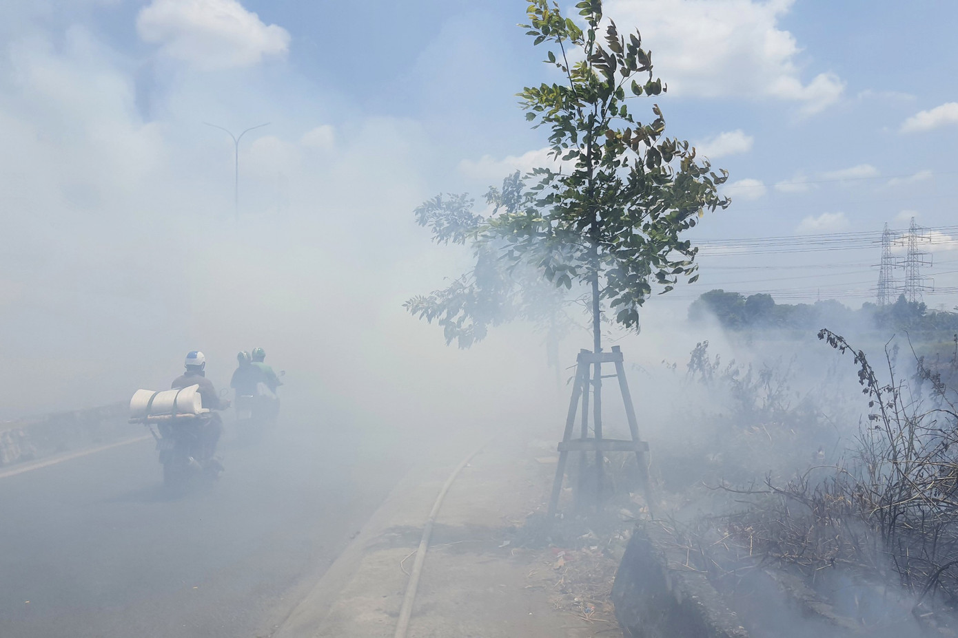 Khói trắng từ đám cháy bao phủ một đoạn trên quốc lộ. Ảnh: Minh Anh.