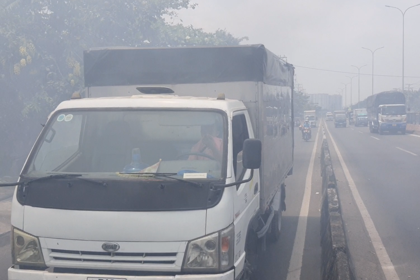 Một tài xế xe tải kéo áo bịt mũi để chống ngạt. Ảnh: Minh Anh.