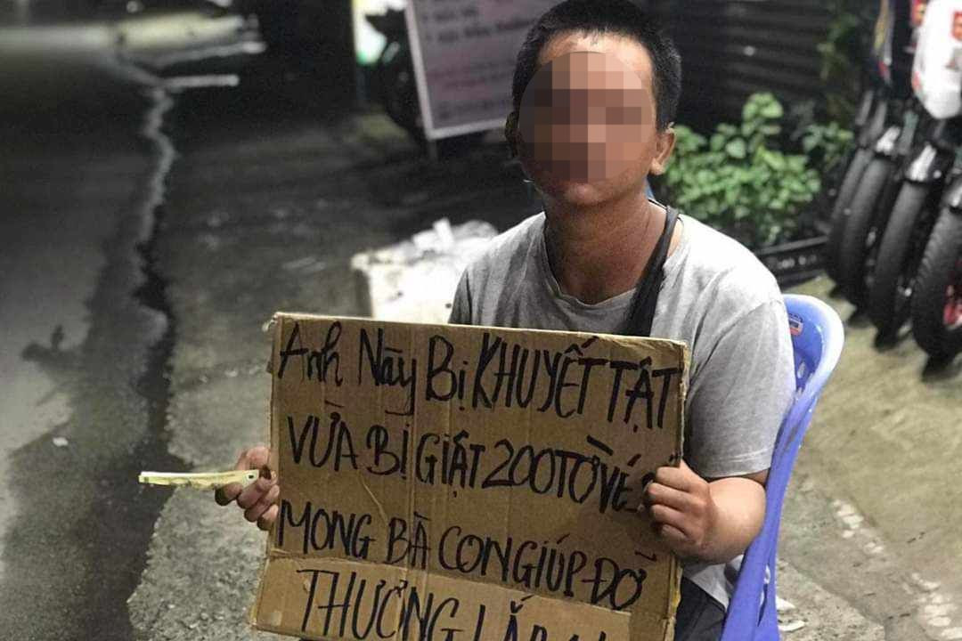 Anh K cầm bìa carton có ghi nội dung thông tin vừa bị giật 200 tờ vé số để mọi người giúp đỡ. Ảnh: A.X. Anh K cầm bìa carton có ghi nội dung thông tin vừa bị giật 200 tờ vé số để mọi người giúp đỡ. Ảnh: A.X.