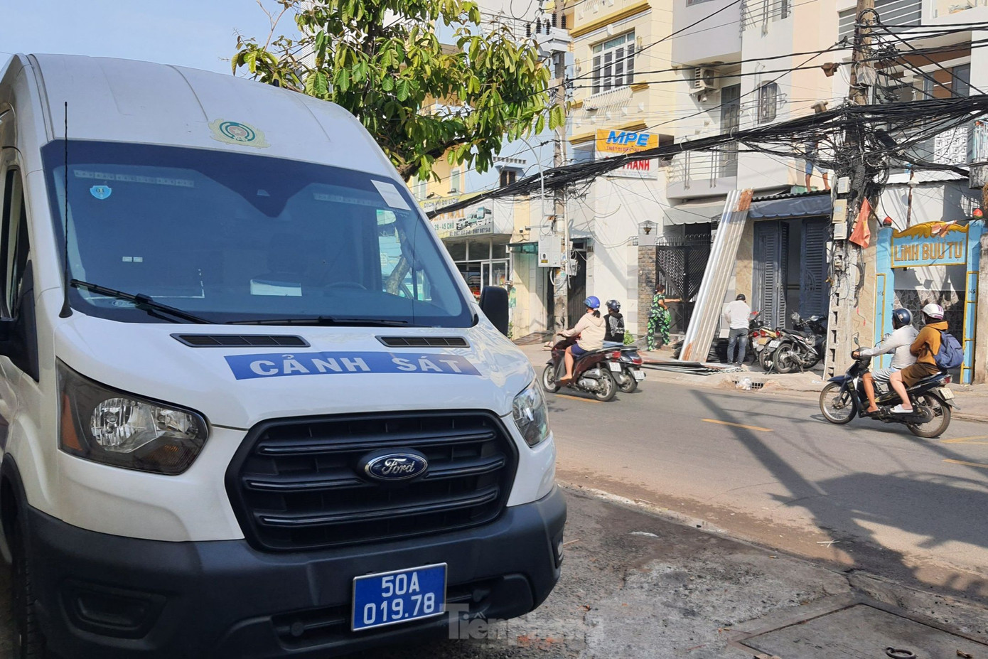 Xe của lực lượng chức năng có mặt trước con hẻm dẫn vào ngôi nhà xảy ra hỏa hoạn. Ảnh: Hoàng Thuận