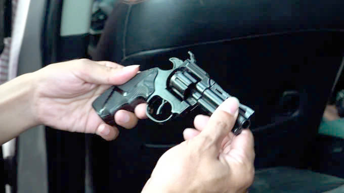 Lực lượng chức năng thu giữ khẩu súng trên ô tô. Ảnh: C.A.