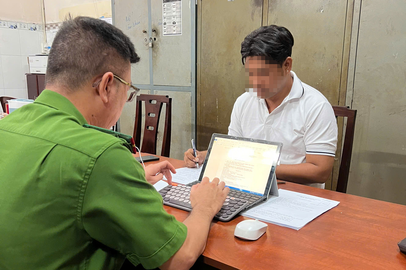 Công an làm việc với người đàn ông đập phá ô tô. Ảnh: C.A.