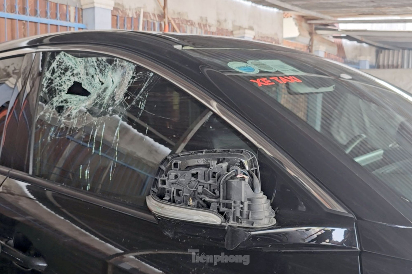 Kính chiếu hậu bên phải và kính chắn gió bị nam thanh niên đập vỡ. Ảnh: H.T.