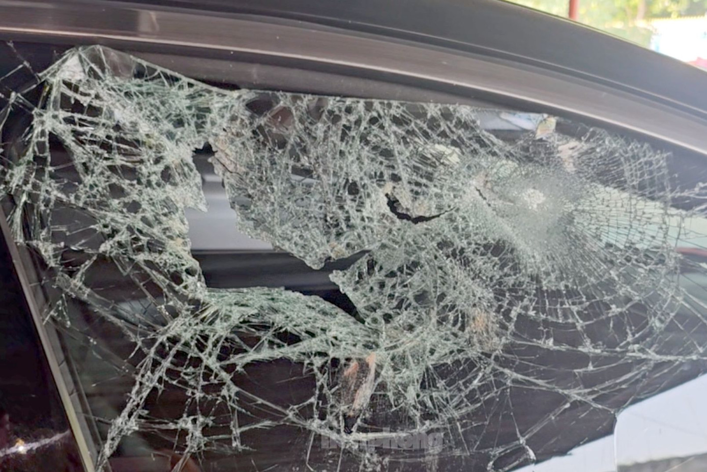 Kính bên phải của ô tô bị đập thủng. Ảnh: H.T.